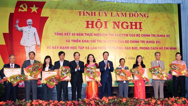 Head of the PCC Commission on Popularization and Education Vo Van Thuong and Secretary of the Lam Dong provincial Party Committee Nguyen Xuan Tien present certificates of merit to outstanding followers of President Ho Chi Minh’s ethical example. (Photo: nhandan.com.vn)