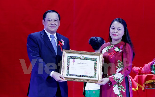 Sonesay Siphandone, Lao Politburo member and Deputy Prime Minister, presents the second-class Itsara Order to Nguyen Thi Thu Ha, President of the Vietnam Women’s Union. (Photo: VNA)