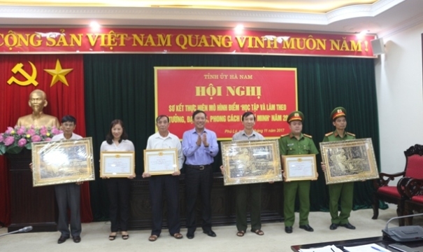 Mr. Loi awards key models on studying and following Uncle Ho’s example. (Photo: nhandan.com.vn)