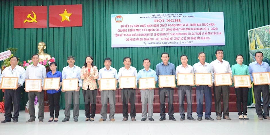 Chairwoman of the city Farmers’ Association Nguyen Thi Bach Mai presents certificates of merit to collectives that make considerable contribution to the resolution implementation. (Photo: thanhuytphcm.vn)
